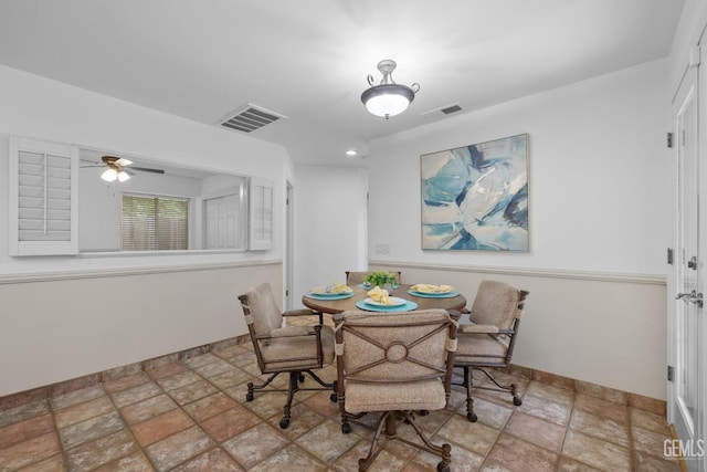 dining space featuring stone finish floor, baseboards, a ceiling fan, and visible vents