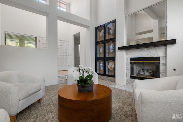 living area with a fireplace and a towering ceiling