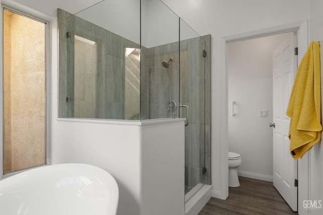full bathroom featuring wood finished floors, baseboards, a stall shower, and toilet