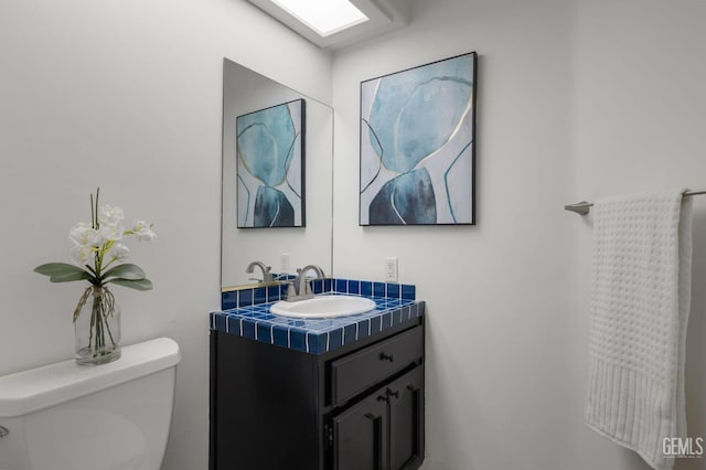 half bathroom featuring vanity and toilet