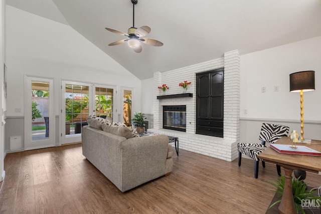 living room featuring a brick fireplace, wood finished floors, high vaulted ceiling, french doors, and a ceiling fan