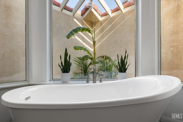 full bath with a textured wall and a soaking tub