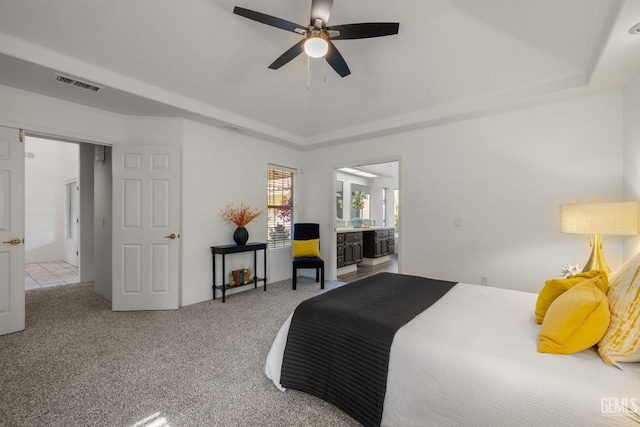 bedroom with a raised ceiling, carpet, and visible vents