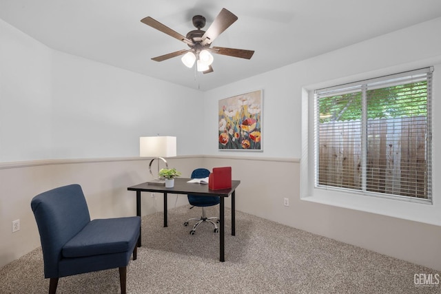 carpeted home office with a ceiling fan