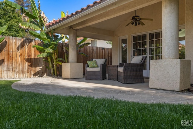view of patio / terrace with ceiling fan and fence