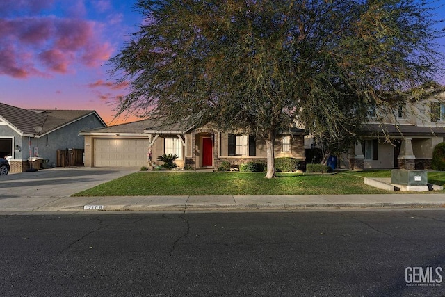 obstructed view of property with a garage and a yard