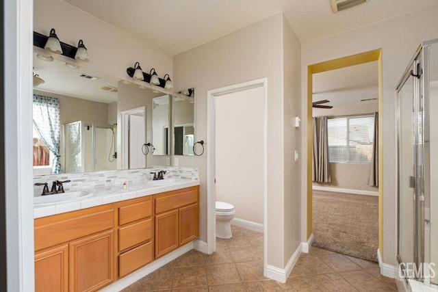 bathroom with plenty of natural light, ceiling fan, a shower with shower door, and vanity