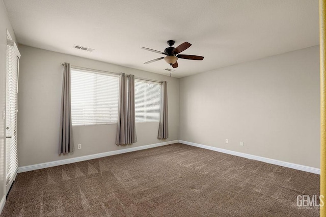 unfurnished room featuring dark colored carpet and ceiling fan