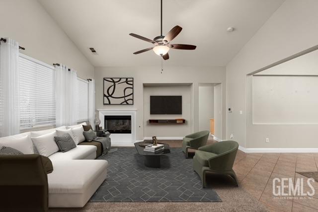 tiled living room with vaulted ceiling and ceiling fan