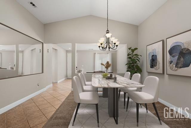 dining area with a notable chandelier, light tile patterned floors, and lofted ceiling