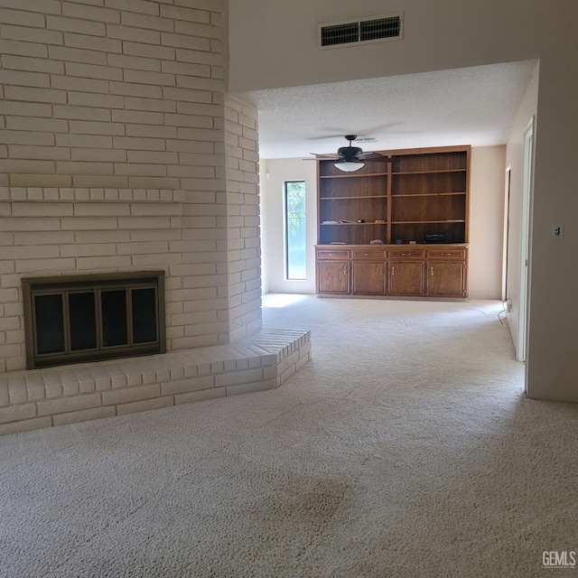 unfurnished living room with a textured ceiling, ceiling fan, light carpet, and a brick fireplace