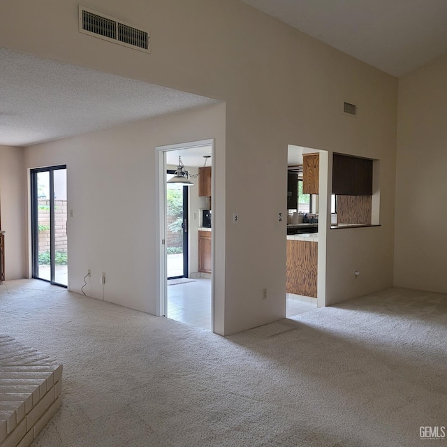 carpeted empty room with a textured ceiling