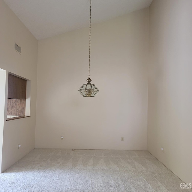 carpeted empty room with lofted ceiling