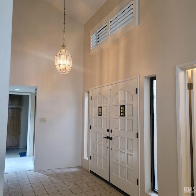 foyer with light tile patterned flooring and a towering ceiling