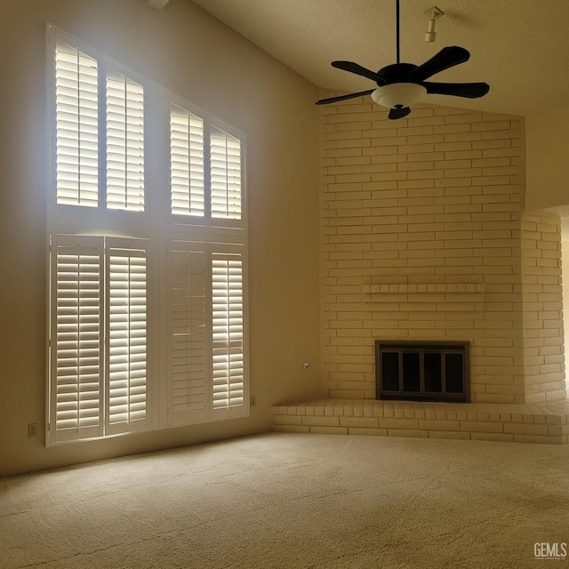 unfurnished living room with carpet flooring, ceiling fan, plenty of natural light, and a brick fireplace