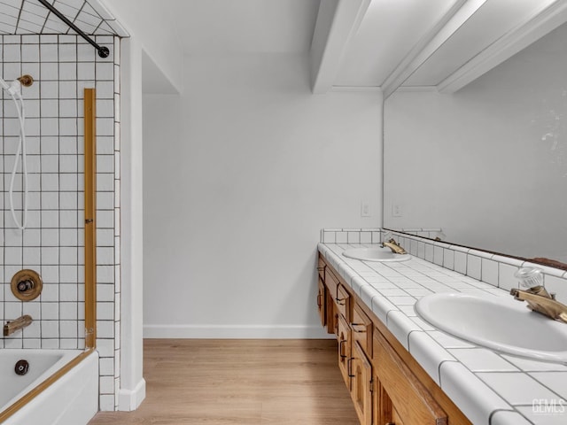 bathroom featuring hardwood / wood-style floors, vanity, and tiled shower / bath