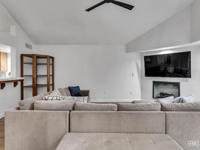 living room featuring wood-type flooring, ceiling fan, and lofted ceiling