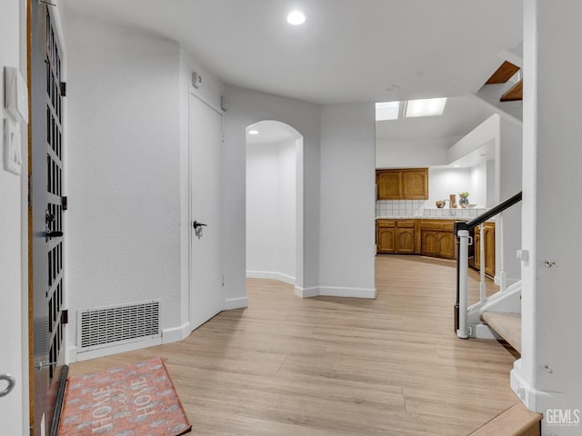 corridor with light hardwood / wood-style floors