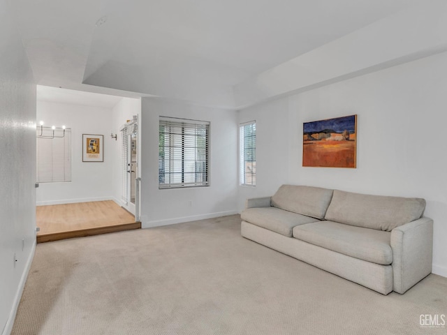 carpeted living room with a notable chandelier