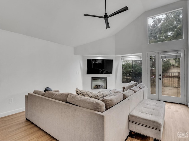 living room with french doors, light wood-type flooring, high vaulted ceiling, and ceiling fan