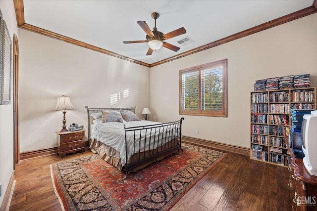 bedroom with hardwood / wood-style flooring, ornamental molding, and ceiling fan