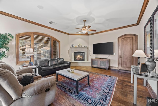 living room with dark wood-type flooring, ornamental molding, and ceiling fan