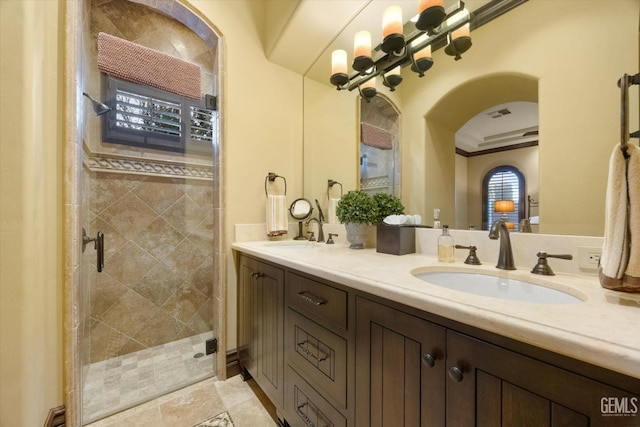 bathroom with a shower with door, vanity, and crown molding