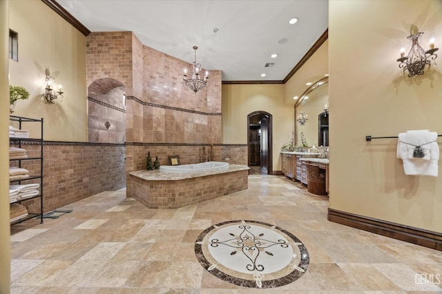 bathroom with vanity, tiled tub, ornamental molding, and a chandelier