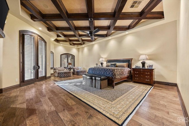 bedroom with light hardwood / wood-style flooring, beam ceiling, coffered ceiling, access to outside, and french doors