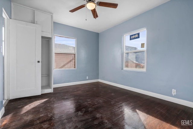 unfurnished bedroom featuring ceiling fan and dark hardwood / wood-style flooring