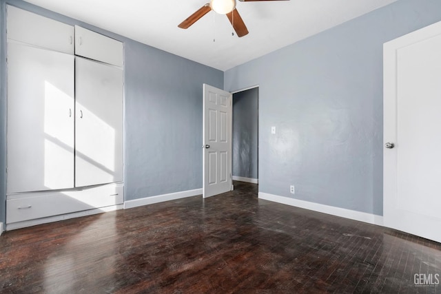 unfurnished room with ceiling fan and dark wood-type flooring