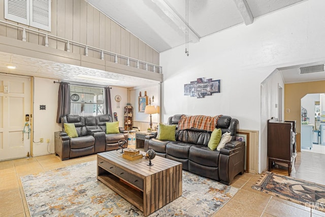 living room featuring beam ceiling, tile patterned floors, and a high ceiling