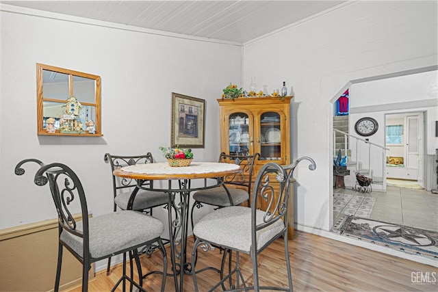 dining space with crown molding and hardwood / wood-style floors