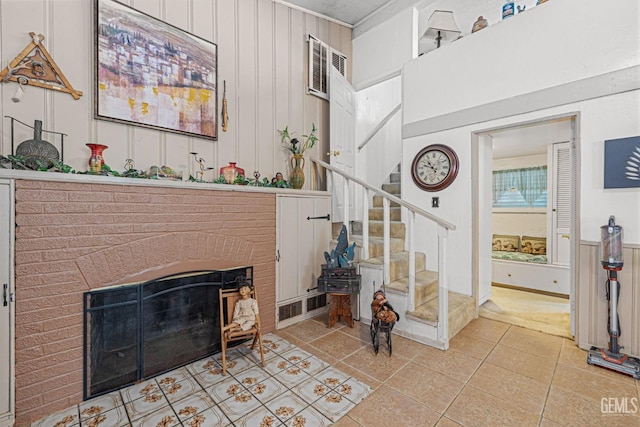 living room featuring wooden walls, a fireplace, and light tile patterned floors