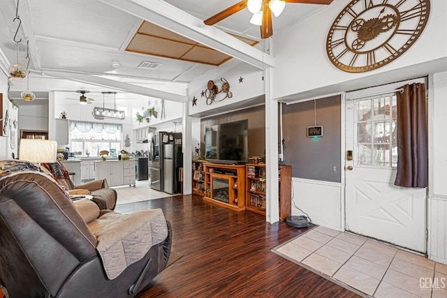 living room with ceiling fan, wood-type flooring, and vaulted ceiling