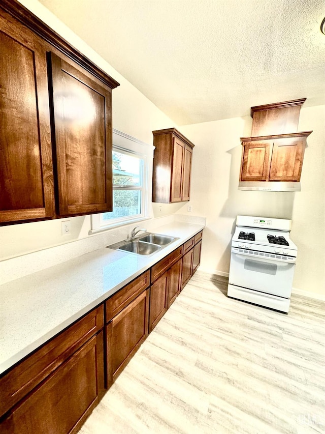 kitchen featuring white gas range, sink, and light hardwood / wood-style floors