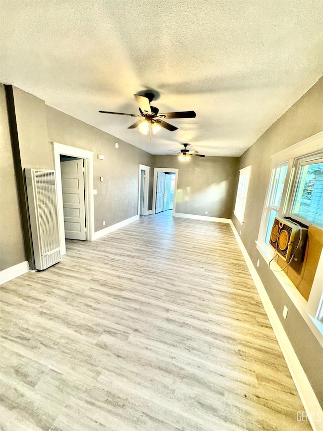 spare room featuring ceiling fan, a textured ceiling, and light hardwood / wood-style flooring