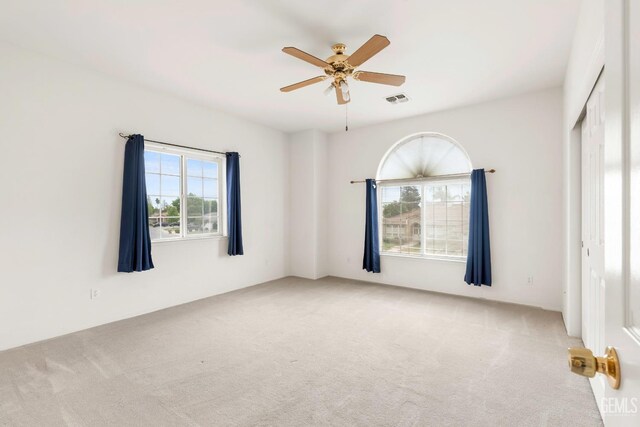 unfurnished bedroom featuring carpet flooring, a closet, visible vents, and a ceiling fan