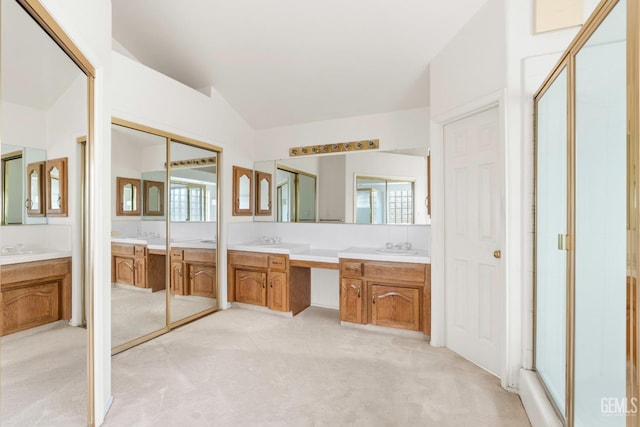 bathroom with a stall shower, two vanities, and a healthy amount of sunlight