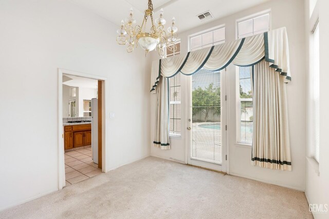 unfurnished dining area with a chandelier, visible vents, light carpet, and light tile patterned flooring