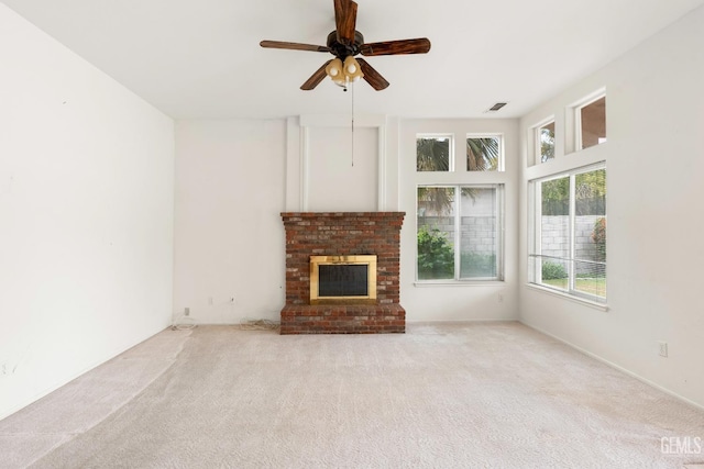 unfurnished living room featuring a brick fireplace, visible vents, a ceiling fan, and carpet floors