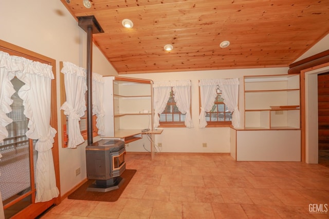 interior space featuring a wood stove, wooden ceiling, and vaulted ceiling