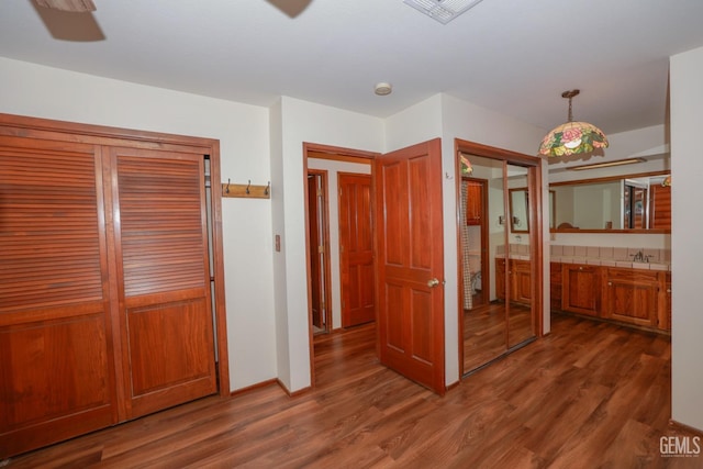 unfurnished bedroom featuring dark hardwood / wood-style floors, ceiling fan, and sink