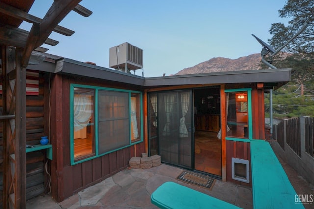 rear view of property with a patio area, a mountain view, and cooling unit