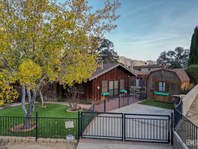 view of front of property with a mountain view, a front yard, and a storage unit