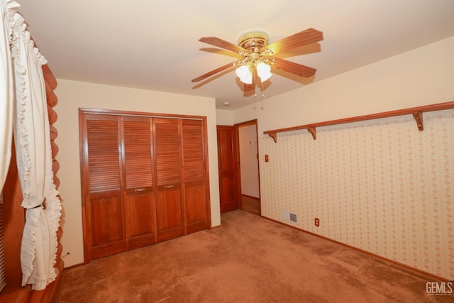 unfurnished bedroom with carpet floors, a closet, and ceiling fan