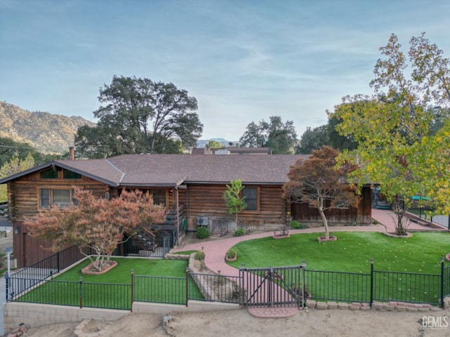 view of front of home featuring a mountain view and a front lawn