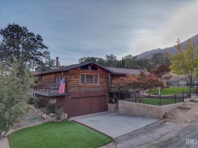 view of front of home with a mountain view, a front lawn, and a garage