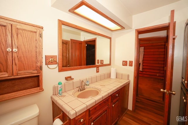 bathroom with hardwood / wood-style floors, vanity, and toilet