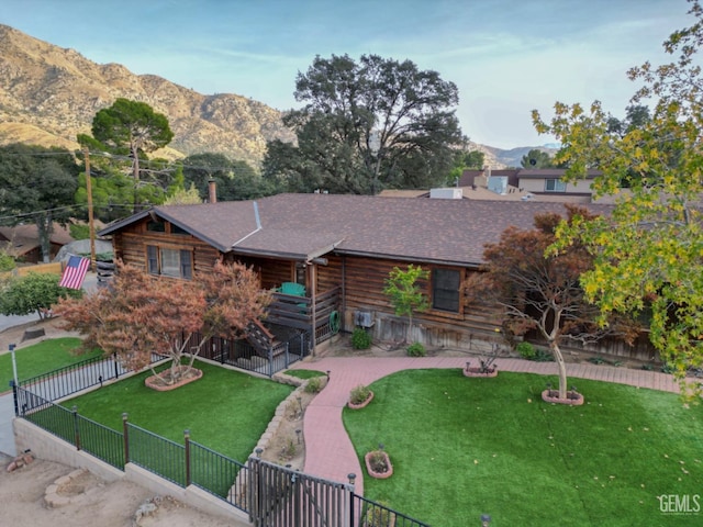 log cabin featuring a mountain view and a front lawn